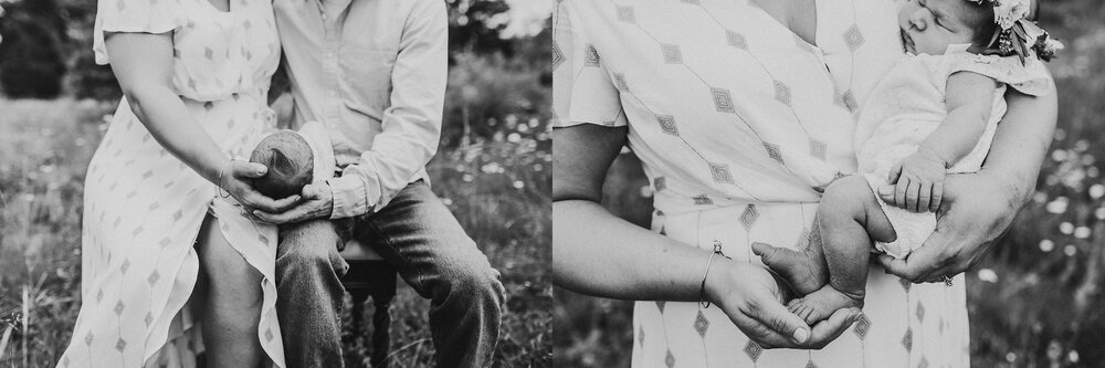 Parent cradling newborn in a field.